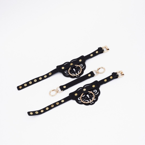 Черные кожаные оковы с резными узорами и клепками